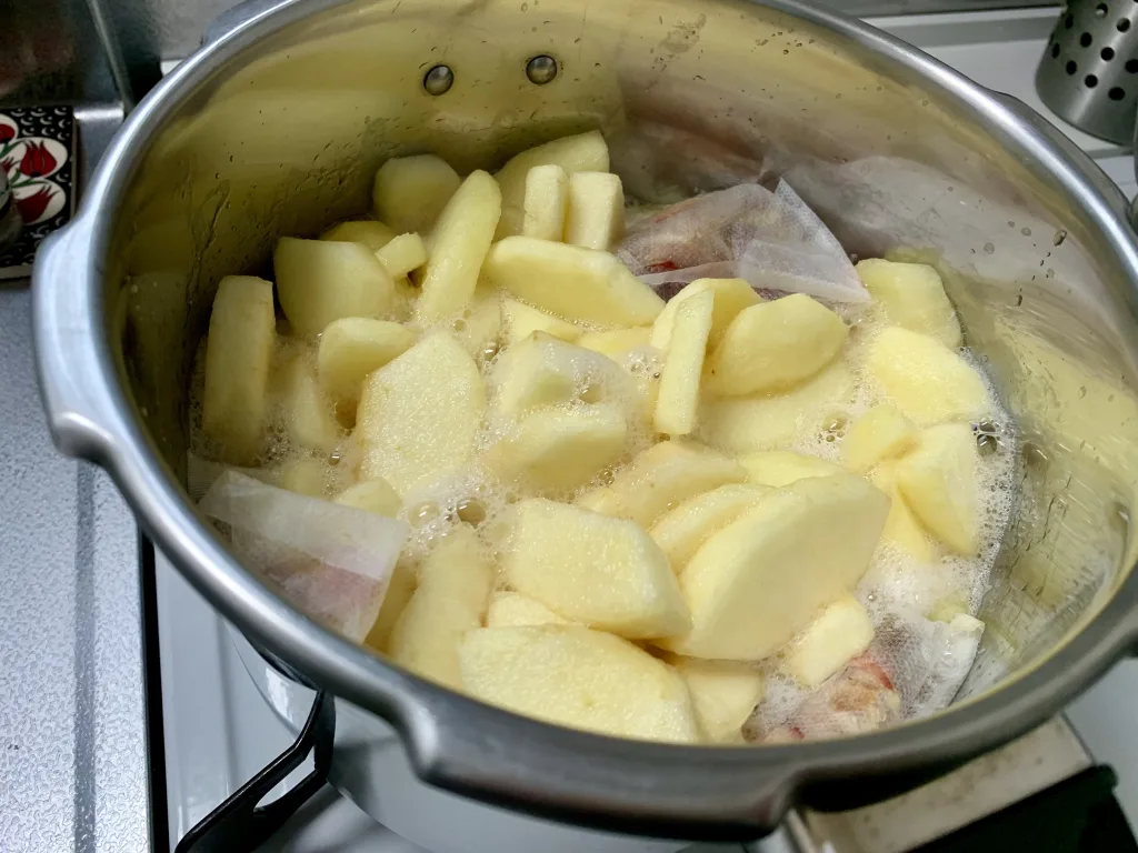ステンレス製の厚手の鍋でりんごを煮る